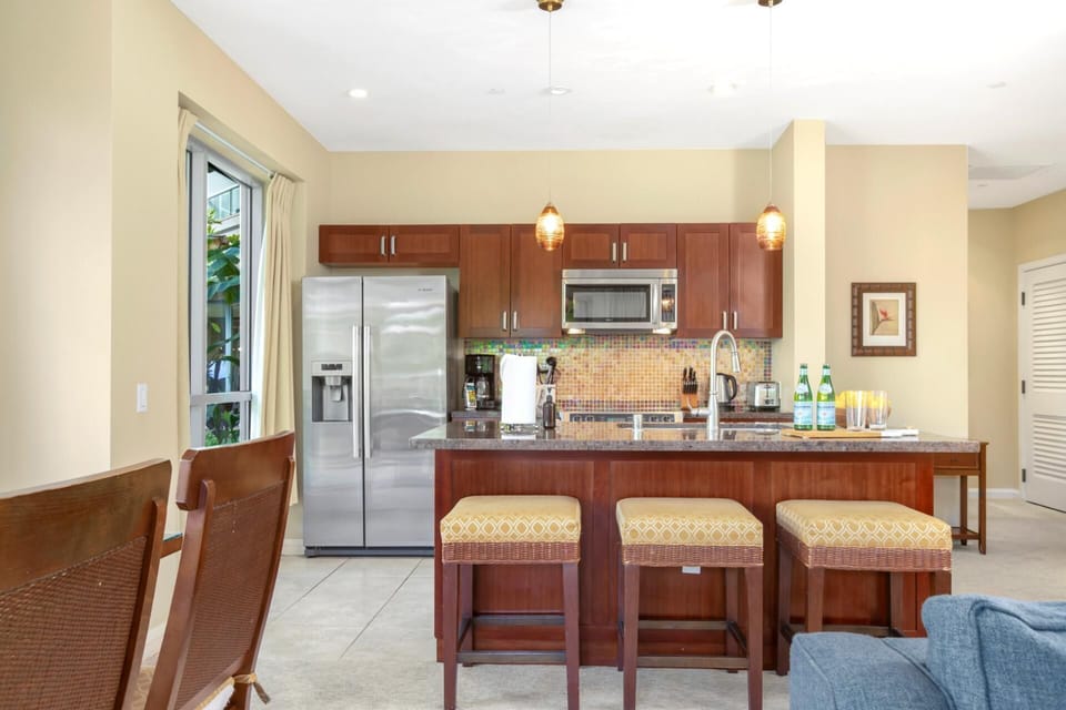 Gourmet kitchen with granite island, stainless appliances, pendant lighting, and bar seating for casual meals