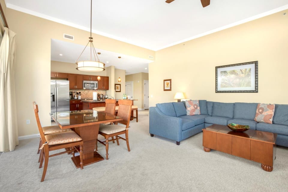 Spacious living and dining setup featuring garden access, comfortable seating, and breezy ceiling fan flow