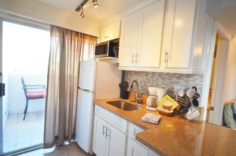Kitchenette with full fridge, microwave, coffee maker, and essentials