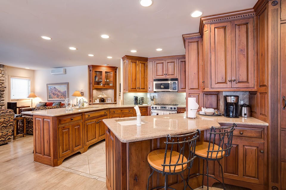 Your gourmet kitchen awaits with rich wood cabinetry, granite countertops, and modern appliances - perfect for creating memorable meals together.