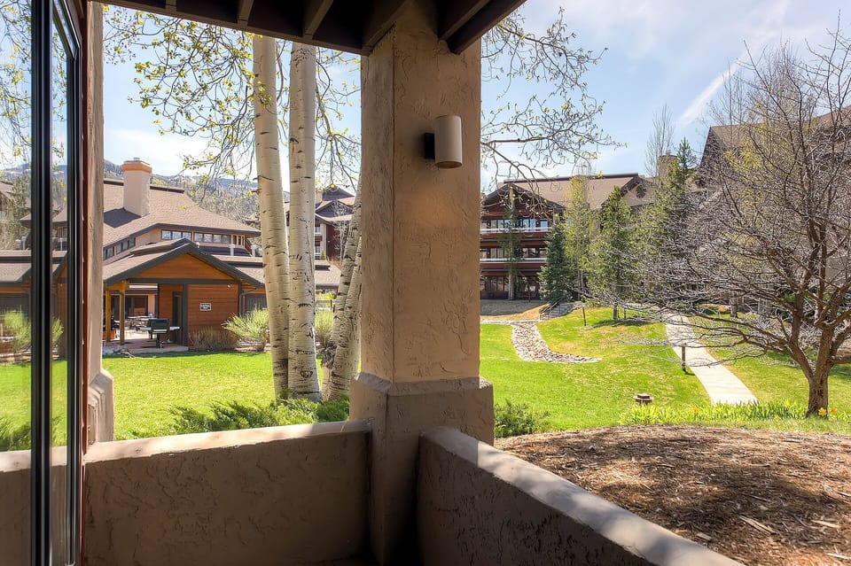 Property grounds with walking paths, green lawns, and peaceful residential buildings surrounded by natural landscape.