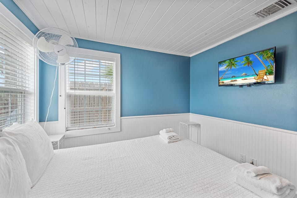 Drift off to sleep in this coastal-inspired bedroom where ocean blue walls and crisp white linens create your perfect beachside retreat.