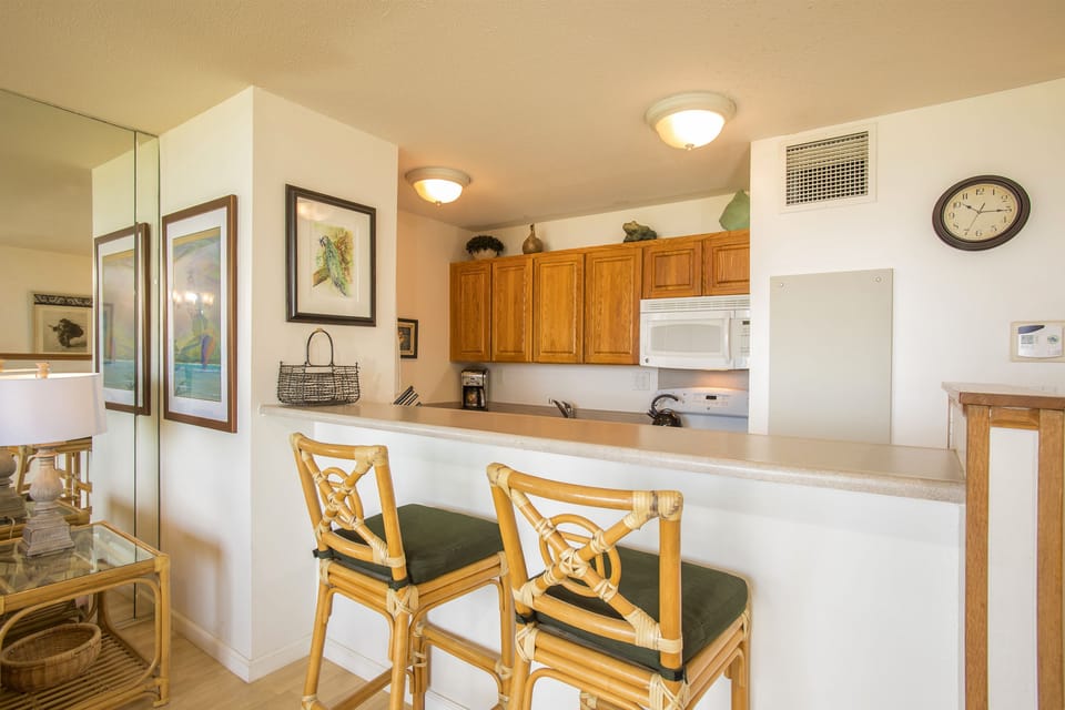 Step into your bright kitchen with warm wood cabinetry, full appliances, and a cozy breakfast bar—perfect for morning coffee or planning your day's adventures.