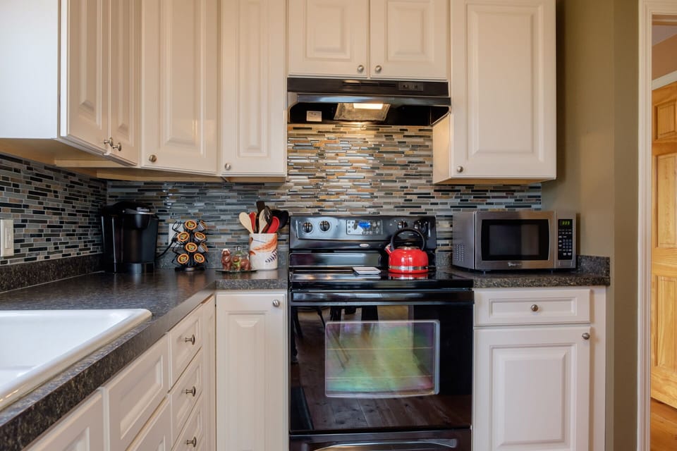 Microwave, Keurig coffee machine, electric stove, and natural stone counter top!