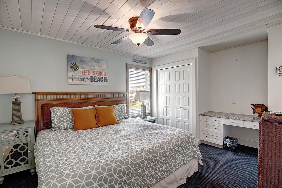 Relax in this coastal bedroom with nautical touches and a ceiling fan keeping you cool.