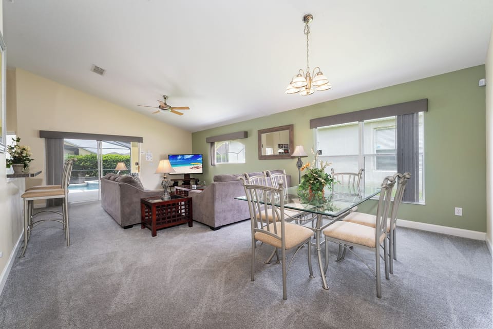 Open floor plan showing dining and living  rooms overlooking the pool