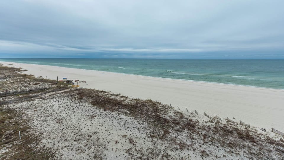Tranquil shoreline with gentle waves and a wide stretch of beach, perfect for relaxation and exploration