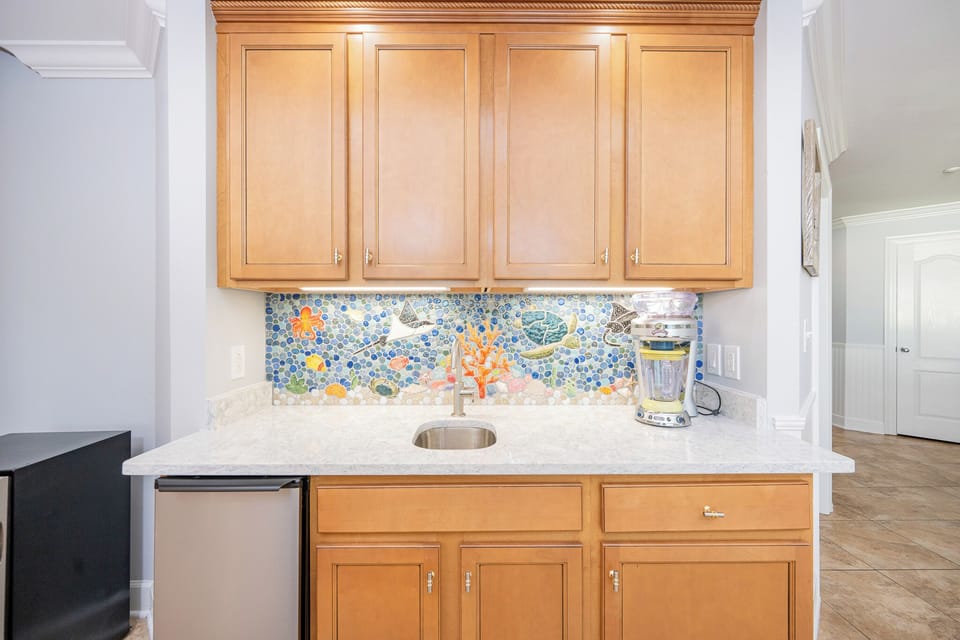 Craft refreshing beverages at the vibrant wet bar, surrounded by lively coastal-inspired decor that boosts your vibe