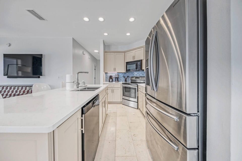 Fully Equipped Kitchen with Quartz Counter-tops and stainless steel appliances, with seating at the island for 4