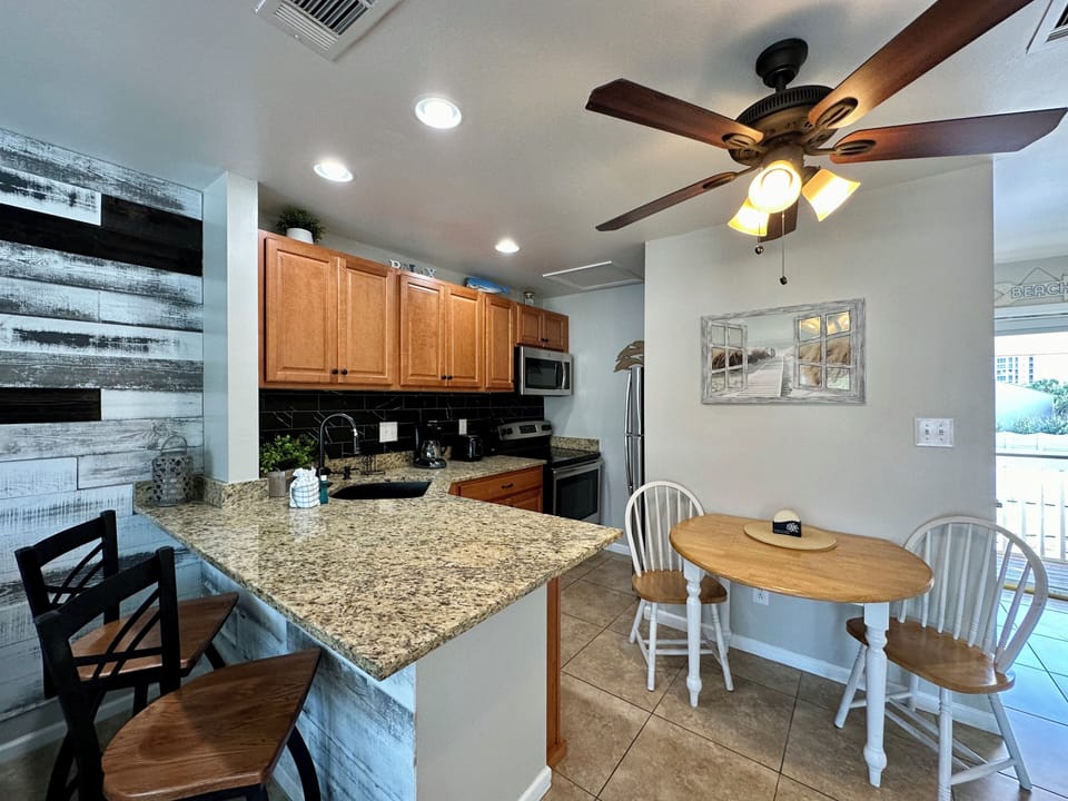Your fully equipped kitchen features granite counters, modern appliances, and a cozy dining nook perfect for morning coffee or vacation meal prep.