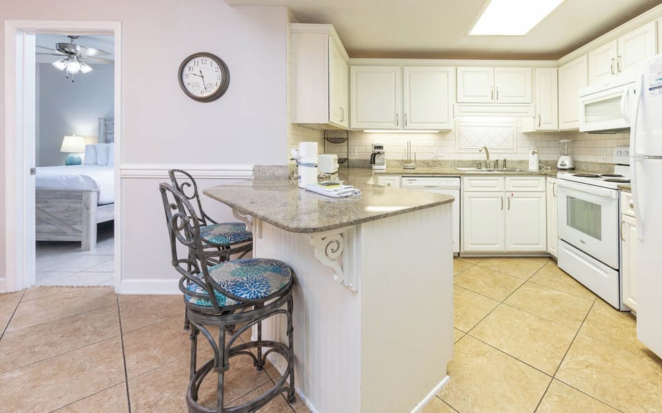 Enjoy preparing meals in the inviting kitchen with a breakfast bar, sleek countertops, and white cabinetry