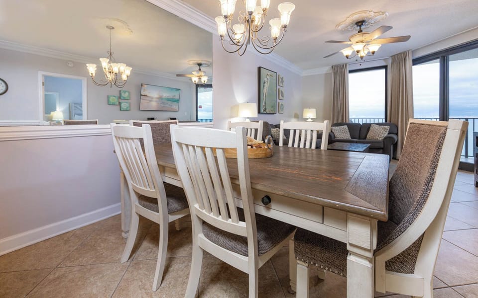 Dine comfortably at the spacious table, surrounded by coastal decor and natural light from the large windows