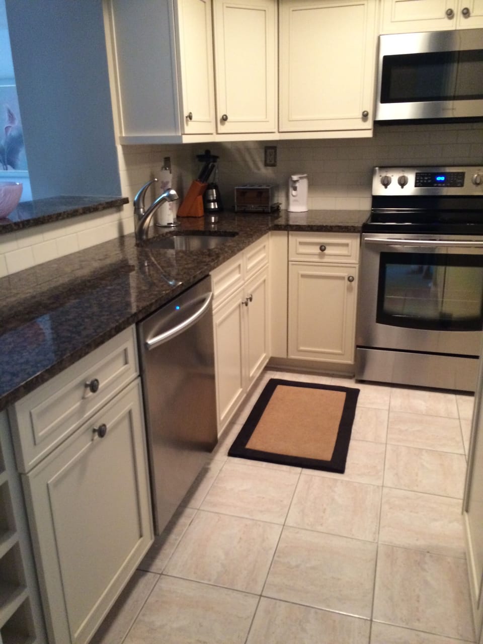 Kitchen including dishwasher and hidden trash recepticles
