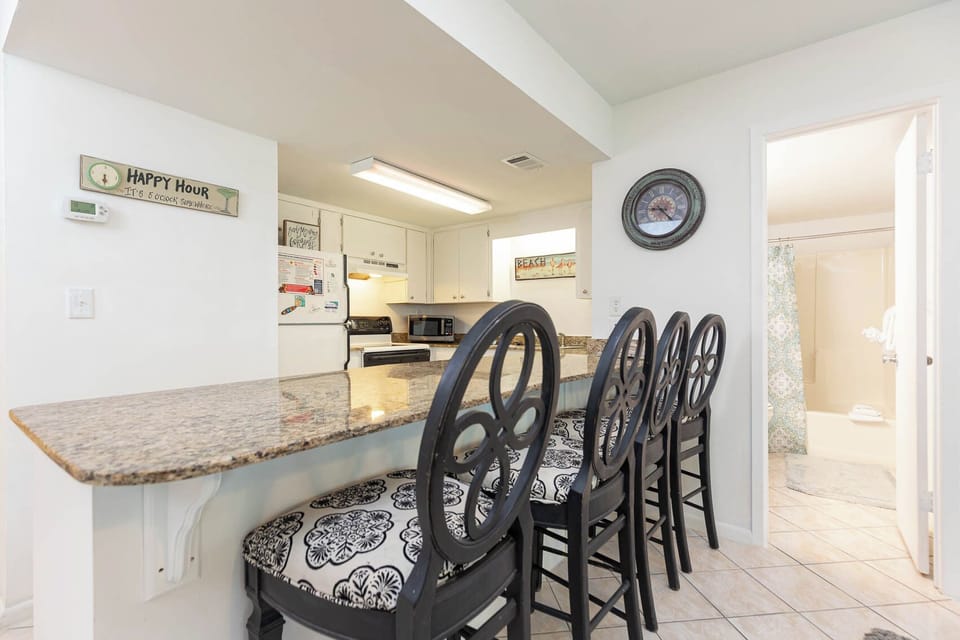 This kitchen features a granite countertop with stylish bar seating, perfect for casual dining and entertaining
