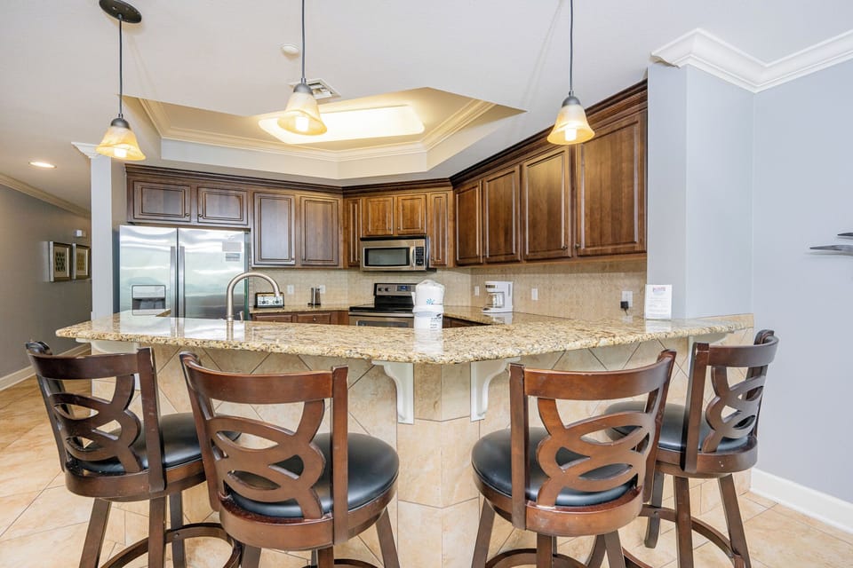 Experience this welcoming kitchen with rich wood cabinetry, granite countertops, and stylish bar seating for casual dining