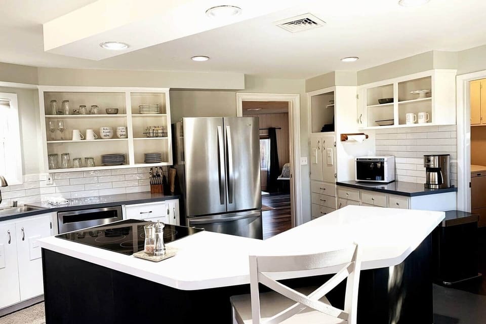 Fully equipped kitchen with island, open shelving, and modern appliances