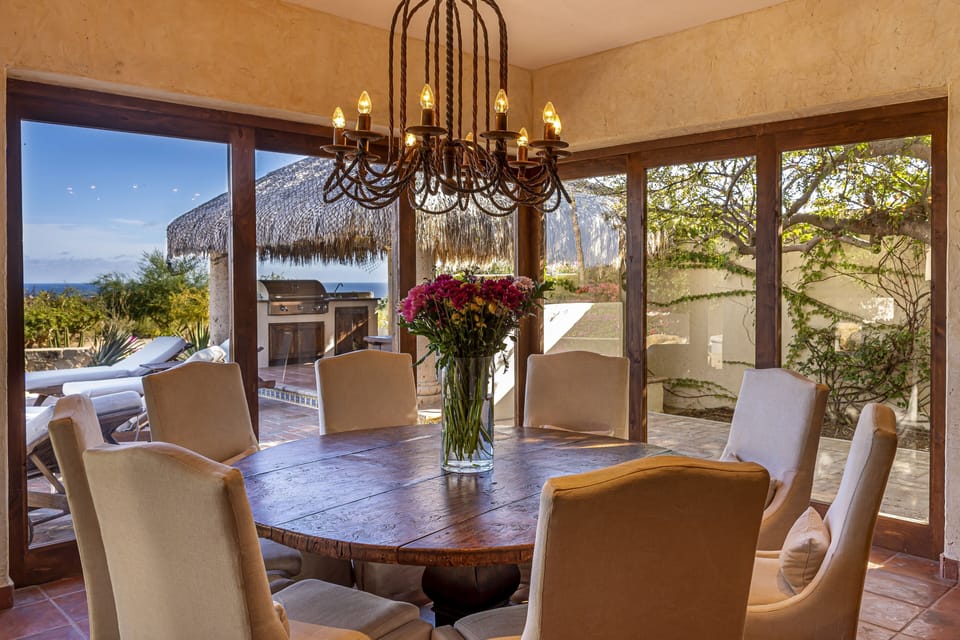 Dinning Room With Glass Doors That Slide Open To Pool and Palapa
