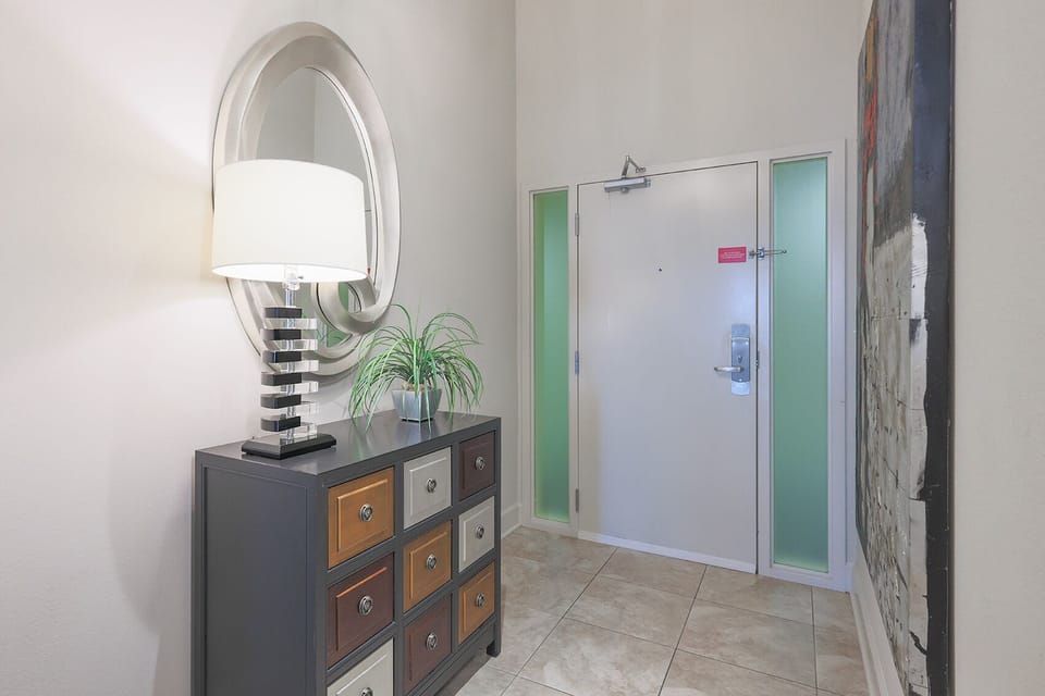 This entryway features a stylish console with colorful drawers, a modern lamp, and a decorative mirror, welcoming you home