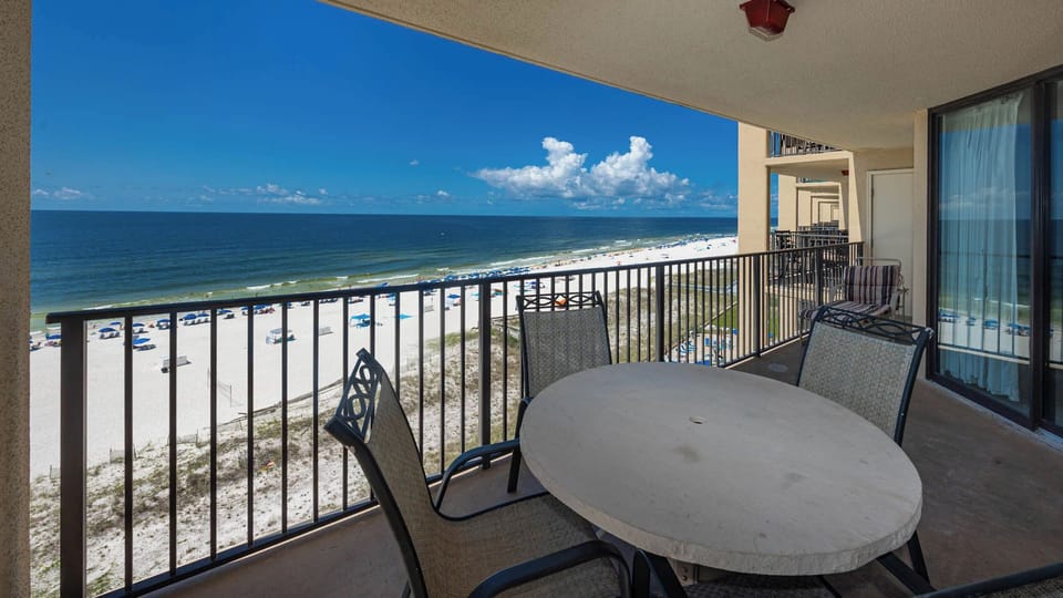 Enjoy the inviting balcony with a round table and chairs, offering a serene view of the beach and tranquil waters