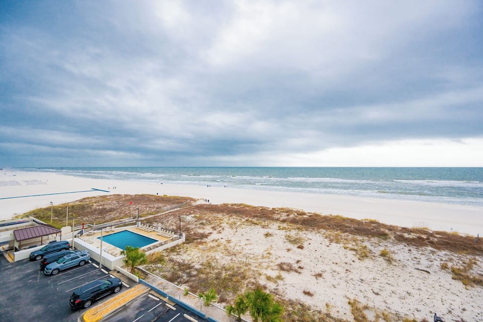 This view showcases a serene beachfront with soft sand and gentle waves, perfect for relaxation and enjoyment