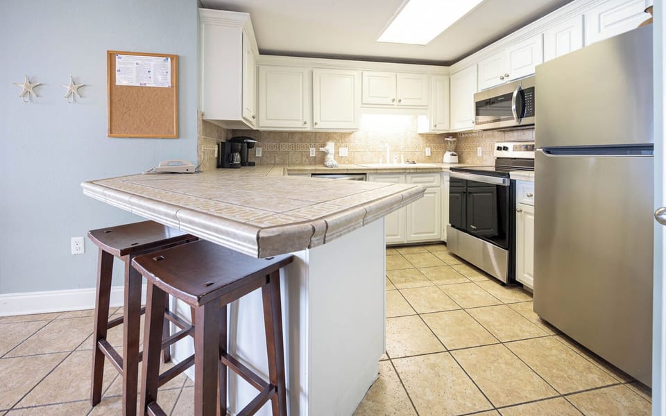 Prepare meals in the functional kitchen featuring stainless steel appliances and a convenient coffee corner with a Keurig