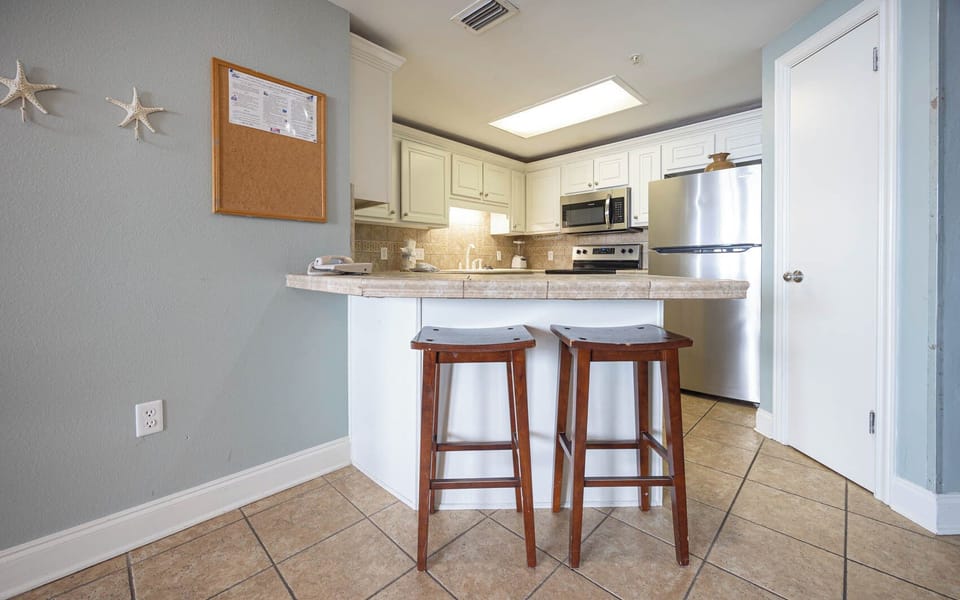 Enjoy casual meals at the breakfast bar with wooden stools, surrounded by a bright and inviting kitchen space