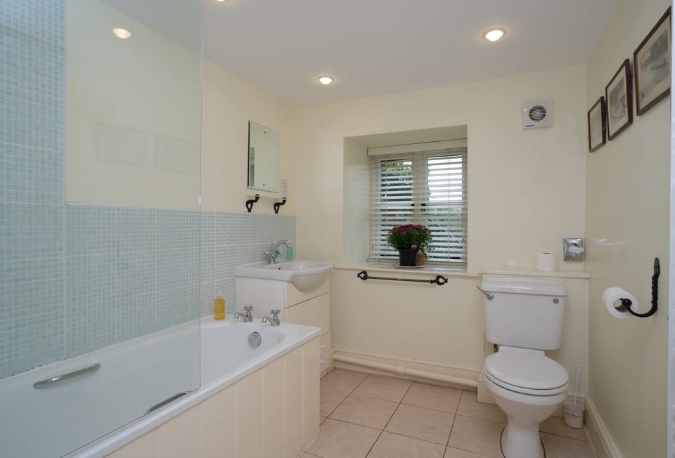 First floor: En suite bathroom with shower over the bath