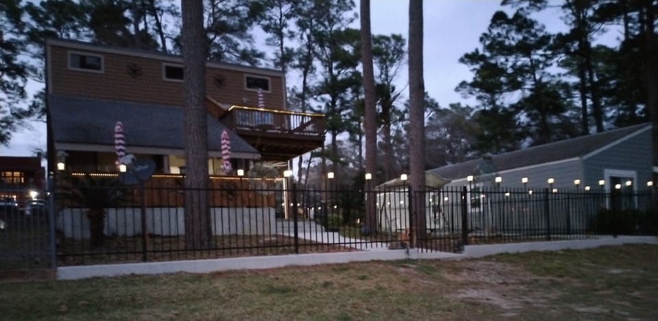 Home in the evening with lights around the fence and around the 2 decks 