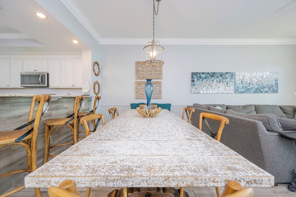 Gather around the rustic dining table, enhanced by coastal decor and a welcoming atmosphere for shared meals