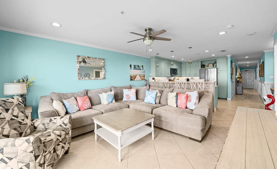 Living & Kitchen — Tan Sectional, Coral Pillows, Shell Mirror & Mint Green Kitchen