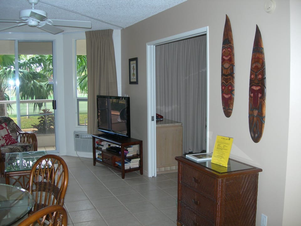 Step into your island-inspired retreat with tropical decor, ceiling fan, and an open living space that flows to lush garden views—ideal for unwinding in paradise.