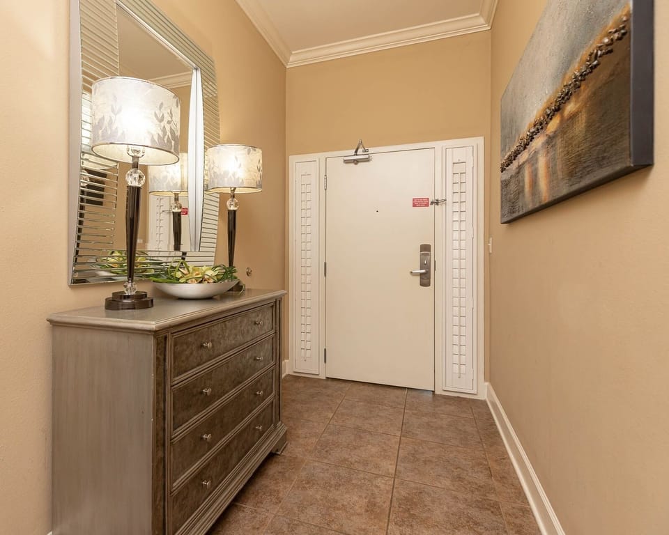This welcoming entryway features stylish lamps and a sleek dresser, setting a warm tone for your stay