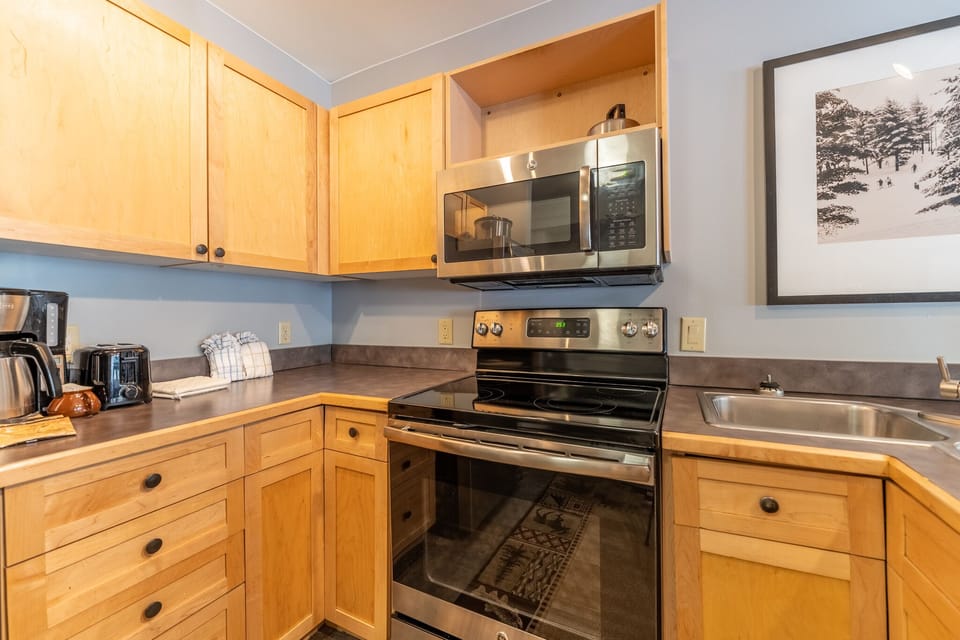 Your fully equipped kitchen features warm wood cabinetry, stainless appliances, and everything you need to create memorable meals during your stay.