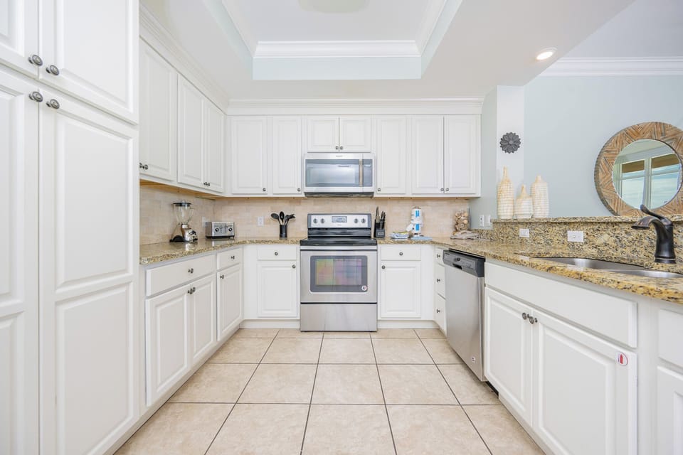 Prepare meals in this bright kitchen featuring granite countertops, stainless appliances, and charming decor