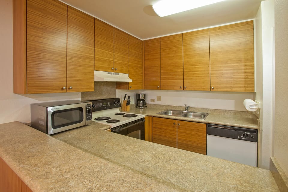 Your fully equipped kitchen awaits, complete with modern appliances, ample counter space, and rich wood cabinetry—everything you need to whip up meals at home.