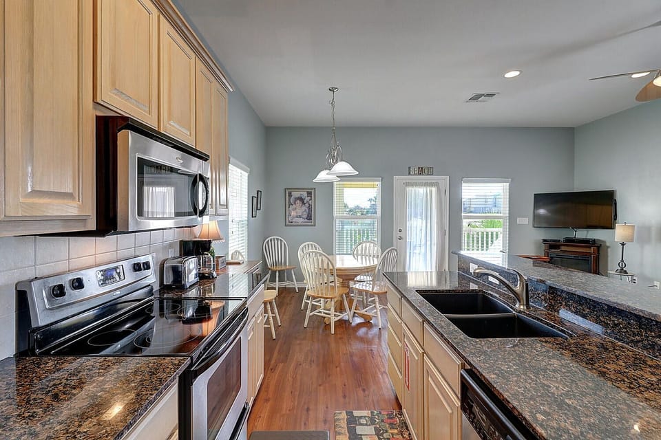 Your fully equipped kitchen features granite counters, modern appliances, and opens to a dining area where meals become memorable moments.