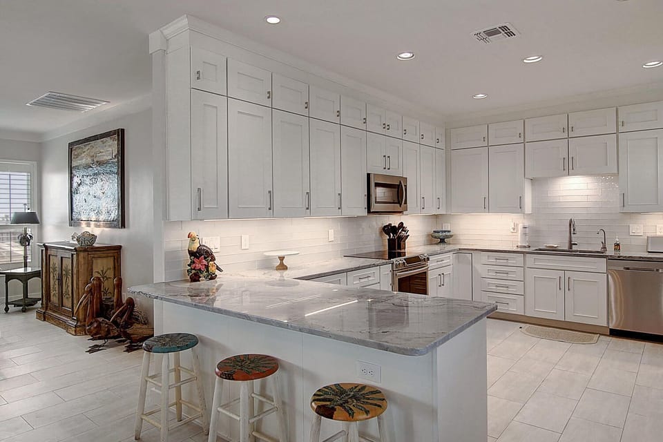 Kitchen - Enjoy a modern kitchen with granite countertops, stainless-steel appliances, and an open layout that combines functionality with coastal charm.