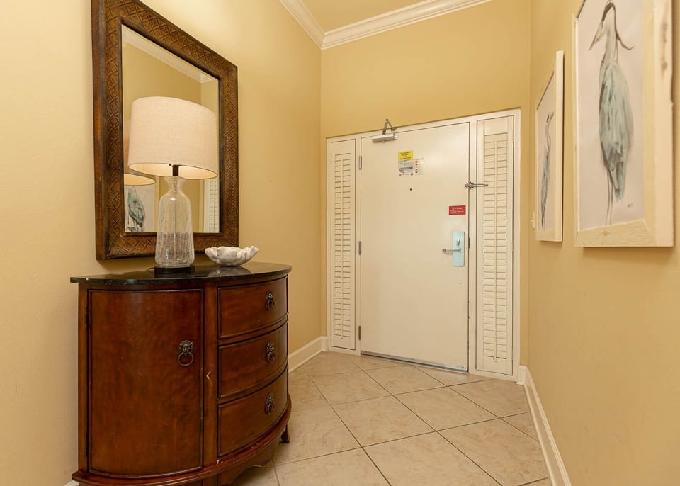 Step into a welcoming entryway adorned with a stylish mirror and a cozy lamp, setting the tone for your beach getaway