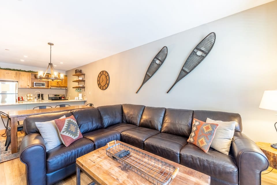 Unwind on plush leather seating in your open-concept living space, where rustic charm meets modern comfort perfectly.