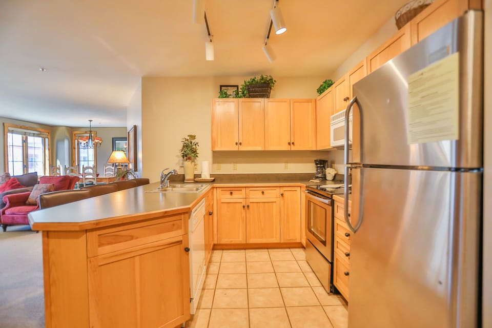 Your fully equipped kitchen features warm wood cabinetry, stainless appliances, and spacious countertops perfect for preparing meals during your stay.