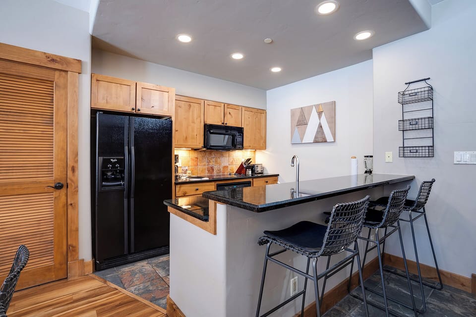 Your fully equipped kitchen features granite counters, modern appliances, and a breakfast bar where you can enjoy morning coffee together.