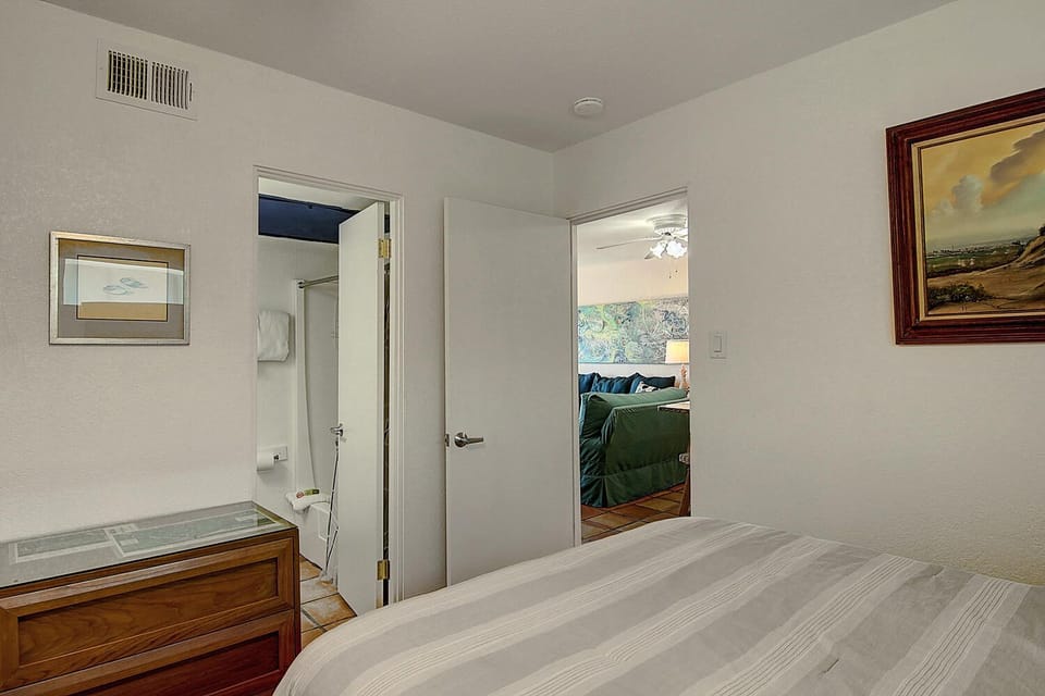 Your comfortable bedroom features elegant artwork and easy access to both bathroom and living spaces for seamless relaxation.