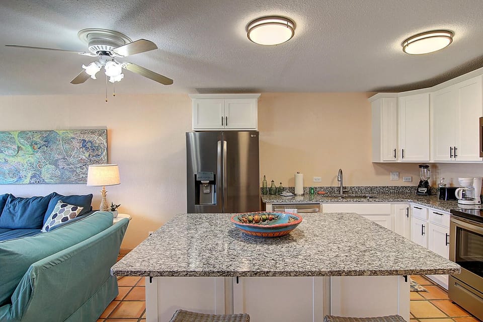 Your open-concept kitchen and living space features granite countertops, stainless appliances, and cozy seating perfect for preparing meals together.