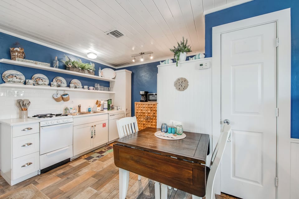 Your charming kitchen awaits with cheerful blue walls, vintage dishes, and everything needed for memorable meals together.