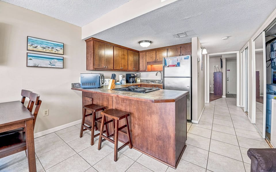 This kitchen features rich wood cabinetry, stainless appliances, and a convenient breakfast bar for casual dining