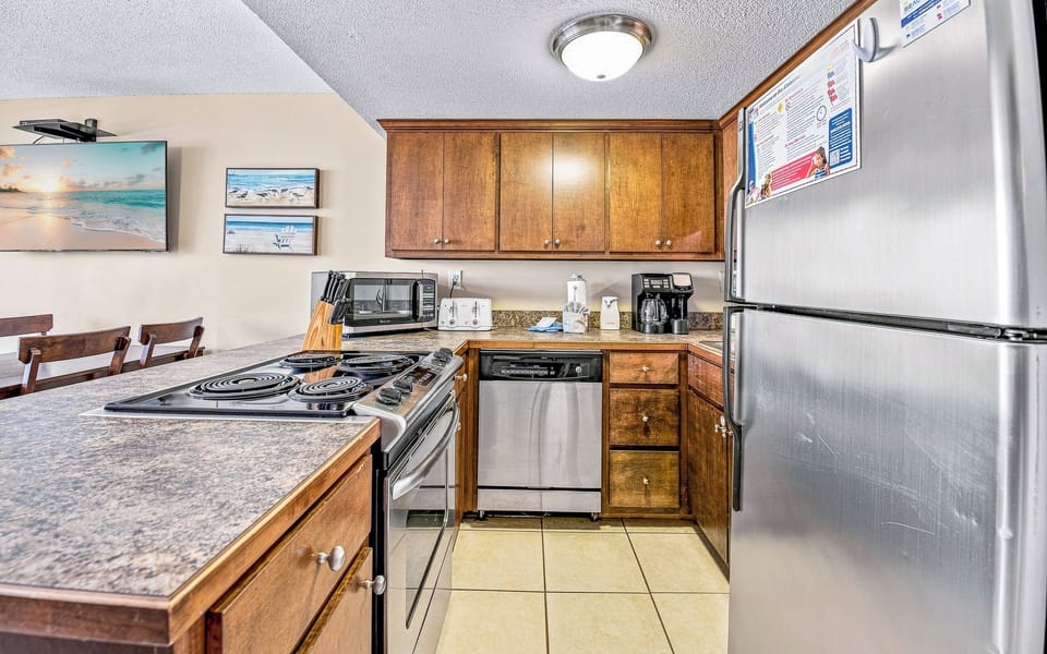 This kitchen features dark wood cabinetry, stainless appliances, and a convenient layout for meal prep and entertaining