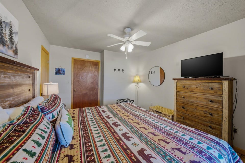 Drift off in your cozy bedroom, where rustic wood furnishings and Native American textiles create a warm mountain retreat atmosphere.