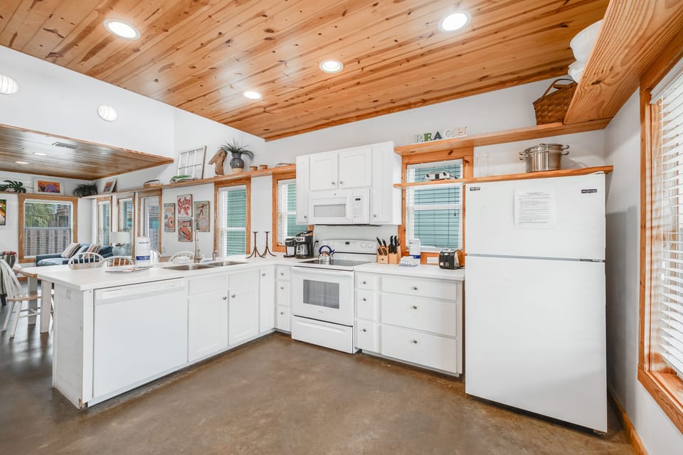 Your spacious kitchen invites culinary adventures with gleaming appliances, exposed wood beams, and ample counter space for memorable meals together.
