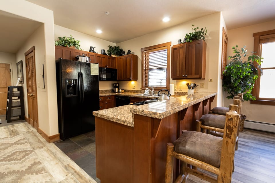 Your fully-equipped kitchen welcomes you with rich wood cabinets, granite counters, and a convenient breakfast bar perfect for morning coffee.