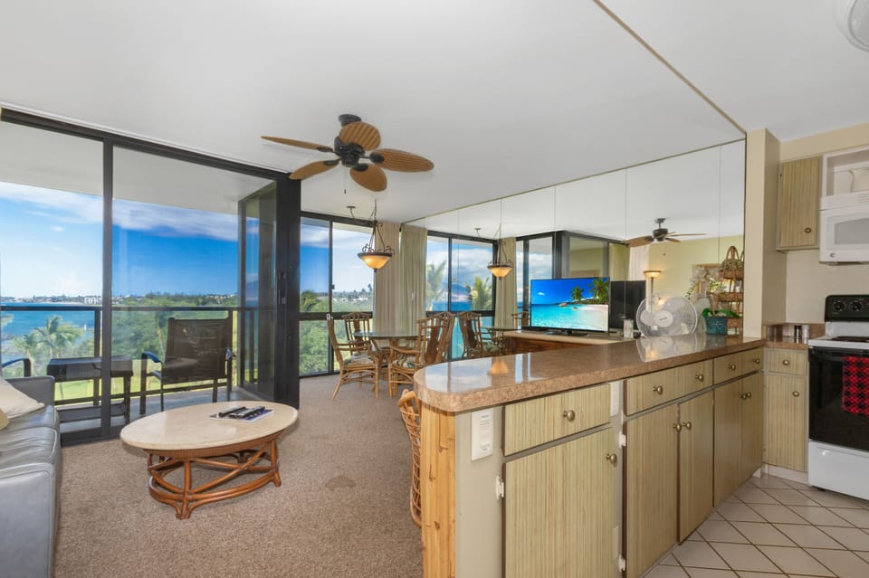 Your open-concept retreat blends island-inspired comfort with stunning views, where natural light pours through floor-to-ceiling windows and tropical breezes drift across the living and dining spaces.